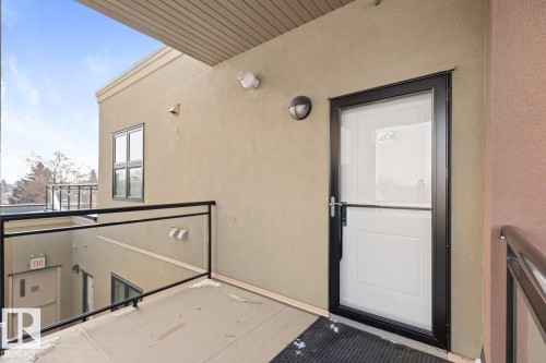 Property entrance featuring a white door with a black frame and a glass panel, set against a tan exterior wall - 406 10811 72 Avenue, Edmonton, AB - Outdoor With Exterior
