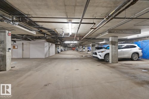 Underground parking space with concrete flooring and exposed ceiling utilities - 406 10811 72 Avenue, Edmonton, AB - Indoor Photo Showing Garage