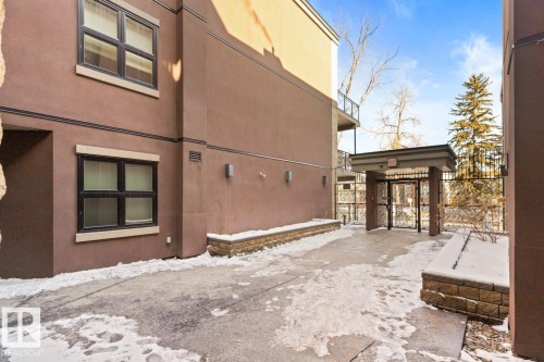 Exterior view of the property showing architectural details, windows with dark frames, and an entrance gate - 406 10811 72 Avenue, Edmonton, AB - Outdoor With Exterior