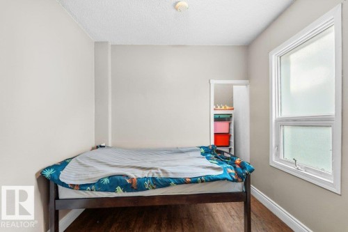 Room featuring wood-finish flooring, a white-framed window, and neutral wall paint - 12207 110 Avenue, Edmonton, AB - Indoor Photo Showing Bedroom