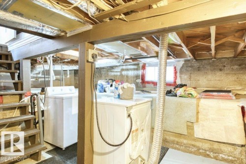Basement area featuring exposed wood joists and support beams, a utility sink, and a washer and dryer - 12207 110 Avenue, Edmonton, AB - Indoor Photo Showing Laundry Room