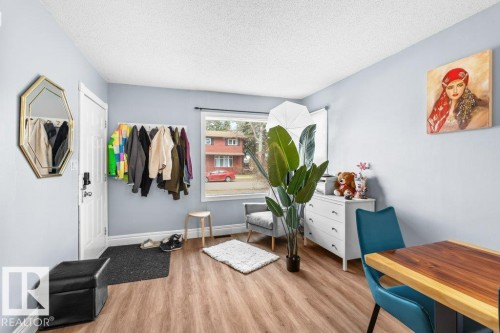 Entryway featuring wood-finish flooring, light blue wall paint, and a white entry door - 12207 110 Avenue, Edmonton, AB - Indoor