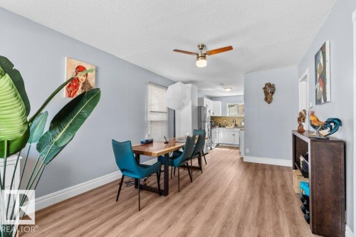 Open-concept dining area featuring wood-finish flooring, a ceiling fan with integrated lighting, and white baseboards - 12207 110 Avenue, Edmonton, AB - Indoor Photo Showing Dining Room