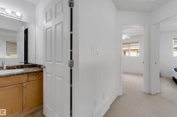 Bathroom vanity with a light wood-finish cabinet, dark speckled countertop, and integrated sink - 