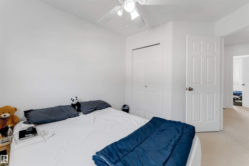 Bedroom featuring a ceiling fan with light fixture, neutral carpeting, and a bi-fold door closet - 48 2503 24 Street, Edmonton, AB - Indoor Photo Showing Bedroom