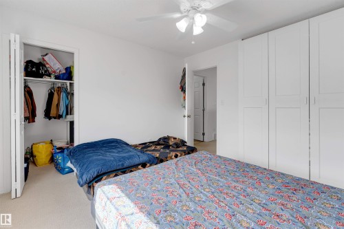 Bedroom featuring light-colored carpeting, a ceiling fan with integrated lighting, and a white bi-fold closet - 48 2503 24 Street, Edmonton, AB - Indoor Photo Showing Bedroom