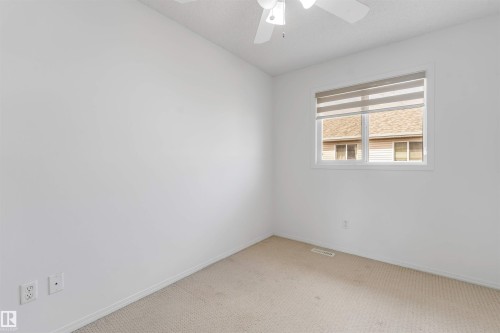 Room featuring neutral carpet flooring, white walls, a single window with blinds, and a ceiling fan with integrated lighting - 48 2503 24 Street, Edmonton, AB - Indoor Photo Showing Other Room