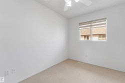 Room featuring neutral carpet flooring, white walls, a single window with blinds, and a ceiling fan with integrated lighting - 