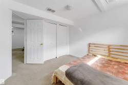 Room featuring neutral carpeting, white walls, two paneled doors, two bi-fold closet doors, and recessed lighting - 