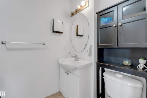 Bathroom vanity with white cabinetry, a ceramic sink, and chrome faucet hardware - 48 2503 24 Street, Edmonton, AB - Indoor Photo Showing Bathroom