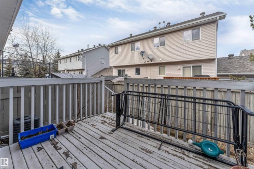 Wooden deck with a white railing and privacy fencing - 48 2503 24 Street, Edmonton, AB - Outdoor With Exterior