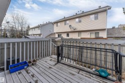Wooden deck with a white railing and privacy fencing - 