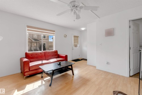 Living area featuring light wood-finish flooring, white walls, and a ceiling fan - 48 2503 24 Street, Edmonton, AB - Indoor Photo Showing Living Room
