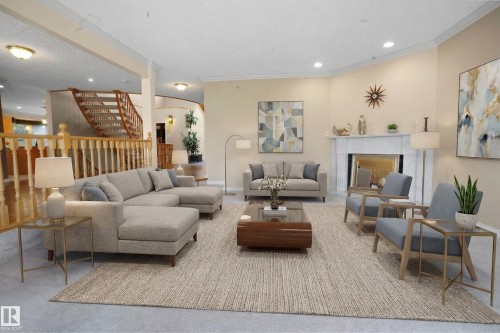 This spacious living area features light-colored walls, a prominent fireplace with a marble mantel, and crown molding - 10815 Bearspaw Dr E Nw, Edmonton, AB - Indoor Photo Showing Living Room With Fireplace
