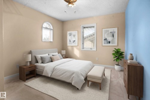This room features a window with an arched top, a second rectangular window, and soft carpeting - 10815 Bearspaw Dr E Nw, Edmonton, AB - Indoor Photo Showing Bedroom
