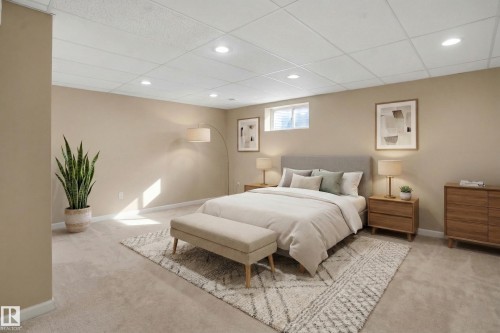 This room features plush carpeting, a drop ceiling with recessed lighting, and neutral-toned walls - 10815 Bearspaw Dr E Nw, Edmonton, AB - Indoor Photo Showing Bedroom