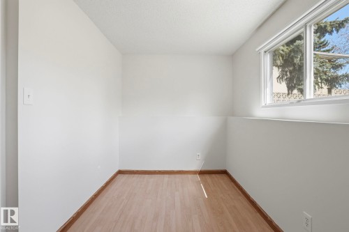 Room with wood-finish flooring, white walls, and a window providing natural illumination - 15811 114 Street, Edmonton, AB - Indoor Photo Showing Other Room