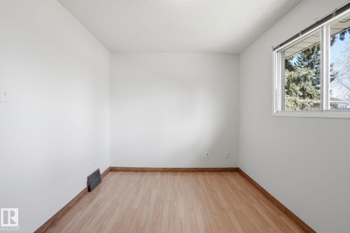 Bright room featuring wood-finish flooring, white walls, and a window with white trim - 15811 114 Street, Edmonton, AB - Indoor Photo Showing Other Room