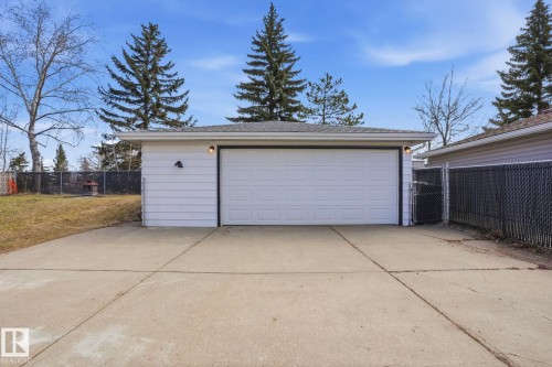 Detached garage with white siding, a single overhead door, and exterior lighting fixtures - 15811 114 Street, Edmonton, AB - Outdoor With Exterior