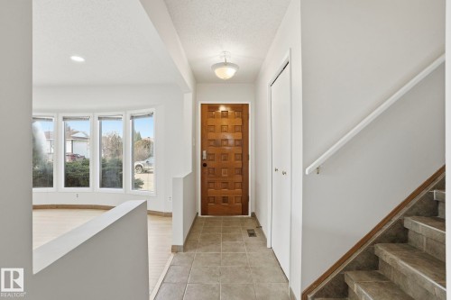 Entryway featuring a wood-panel door, tile flooring, recessed lighting, and a bay window - 15811 114 Street, Edmonton, AB - Indoor Photo Showing Other Room