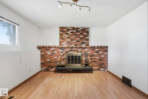 Brick fireplace with an arched firebox, hearth, and mantel - 15811 114 Street, Edmonton, AB - Indoor With Fireplace