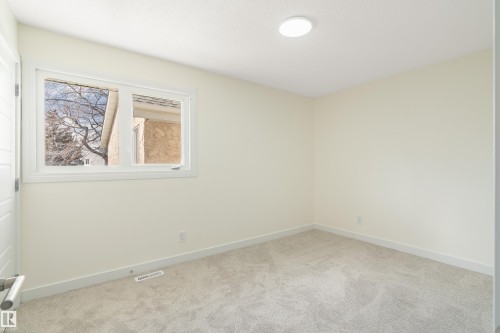 Room featuring light-toned carpeting, neutral wall paint, and white baseboards - 15C Callingwood Crest, Edmonton, AB - Indoor Photo Showing Other Room