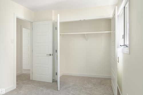 Carpeted room with a built-in closet and a window providing natural light - 15C Callingwood Crest, Edmonton, AB - Indoor