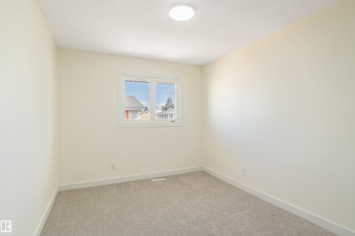 Neutral-toned interior room featuring light-colored walls, a double-paned window, and a flush-mount ceiling light fixture - 15C Callingwood Crest, Edmonton, AB - Indoor Photo Showing Other Room