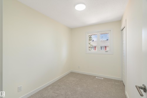 Bright room featuring neutral wall paint, light-toned carpeting, a window with white trim, and a flush-mount ceiling light fixture - 15C Callingwood Crest, Edmonton, AB - Indoor Photo Showing Other Room