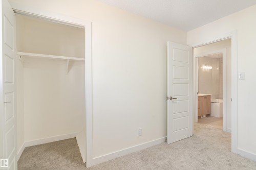 Carpeted room with a closet featuring a single shelf and hanging rod - 15C Callingwood Crest, Edmonton, AB - Indoor Photo Showing Other Room