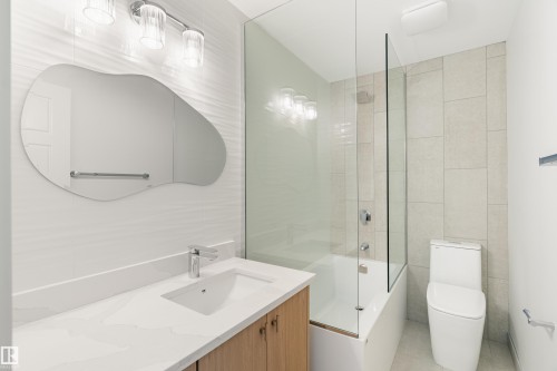 Contemporary bathroom featuring a light wood-finish vanity with an integrated sink and chrome faucet - 15C Callingwood Crest, Edmonton, AB - Indoor Photo Showing Bathroom