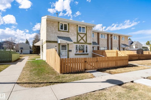 Two-story duplex featuring a stucco and siding exterior with decorative green trim - 15C Callingwood Crest, Edmonton, AB - Outdoor