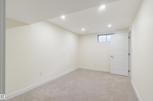 Carpeted room featuring recessed lighting, a horizontal window, and a white paneled door - 15C Callingwood Crest, Edmonton, AB - Indoor