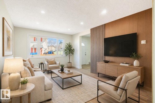 Living room featuring a wood-panel accent wall, recessed lighting, large picture window, and wood-finish flooring - 15C Callingwood Crest, Edmonton, AB - Indoor Photo Showing Living Room