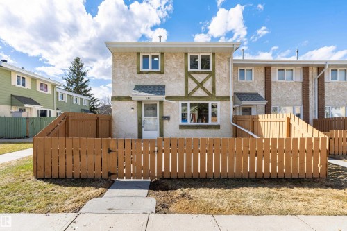 Two-story stucco and wood-trim exterior featuring a private fenced front yard - 15C Callingwood Crest, Edmonton, AB - Outdoor
