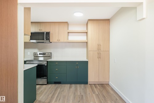 Kitchen featuring wood-finish upper cabinetry, open shelving, and a pantry - 15C Callingwood Crest, Edmonton, AB - Indoor Photo Showing Kitchen