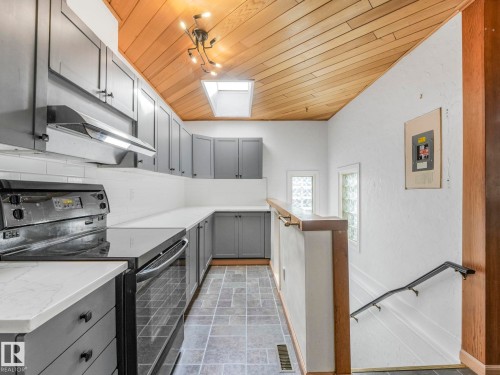 Modern kitchen featuring grey cabinetry, white subway tile backsplash, white countertops, and a black electric range with an overhead vent - 11643 76 Avenue, Edmonton, AB - Indoor Photo Showing Kitchen