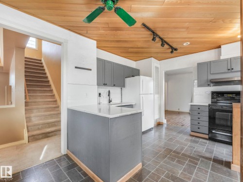 Kitchen featuring gray cabinetry, white countertops, dark square tile flooring, and a wood-paneled ceiling - 11643 76 Avenue, Edmonton, AB - Indoor Photo Showing Kitchen