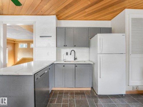 Kitchen featuring slate tile flooring, white quartz countertops, gray cabinetry, white subway tile backsplash, and a black gooseneck faucet - 11643 76 Avenue, Edmonton, AB - Indoor Photo Showing Kitchen