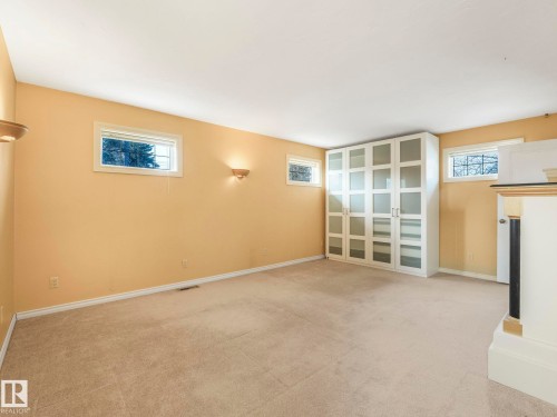 Spacious room featuring neutral carpeting, light-toned walls, and multiple windows - 11643 76 Avenue, Edmonton, AB - Indoor