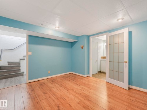Room featuring wood-finish flooring, light blue walls, and a white acoustical tile ceiling - 11643 76 Avenue, Edmonton, AB - Indoor Photo Showing Other Room