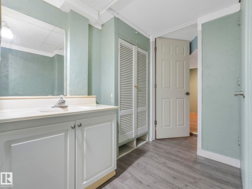 Bathroom vanity featuring a white countertop with an integrated sink and chrome faucet - 11643 76 Avenue, Edmonton, AB - Indoor