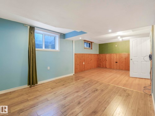 Versatile finished basement space featuring light wood-finish flooring - 11643 76 Avenue, Edmonton, AB - Indoor