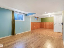 Versatile finished basement space featuring light wood-finish flooring - 