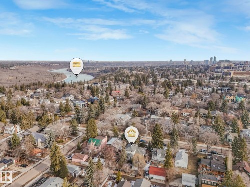 Aerial perspective showcasing a residential neighborhood with a river and city skyline in the background - 11643 76 Avenue, Edmonton, AB - Outdoor With View
