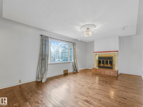 Interior with wide plank wood-finish flooring - 11643 76 Avenue, Edmonton, AB - Indoor Photo Showing Living Room With Fireplace