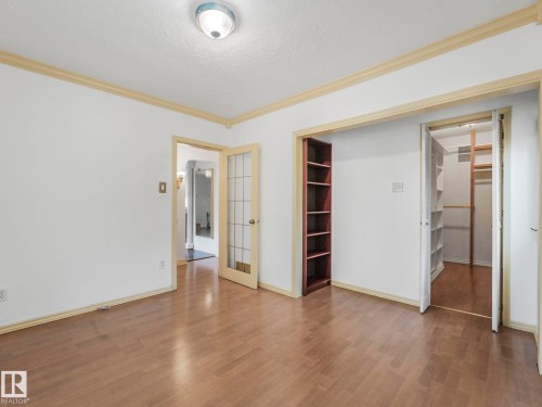 Neutral wall color with contrasting trim and wood-finish flooring - 11643 76 Avenue, Edmonton, AB - Indoor Photo Showing Other Room