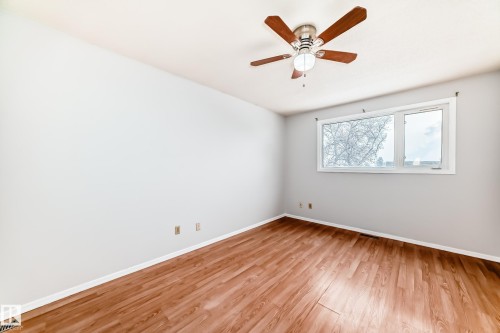 Room featuring wood-finish flooring, a ceiling fan with light fixture, and a white-framed window - 3325 107 Avenue Nw, Edmonton, AB - Indoor Photo Showing Other Room