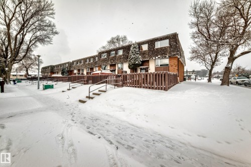 Row of townhomes featuring brick and shingle siding, individual fenced patios, and multiple windows - 3325 107 Avenue Nw, Edmonton, AB - Outdoor