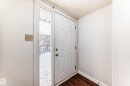 Entryway featuring a paneled door, wood-finish flooring, and white painted walls - 3325 107 Avenue Nw, Edmonton, AB  - Indoor Photo Showing Other Room 